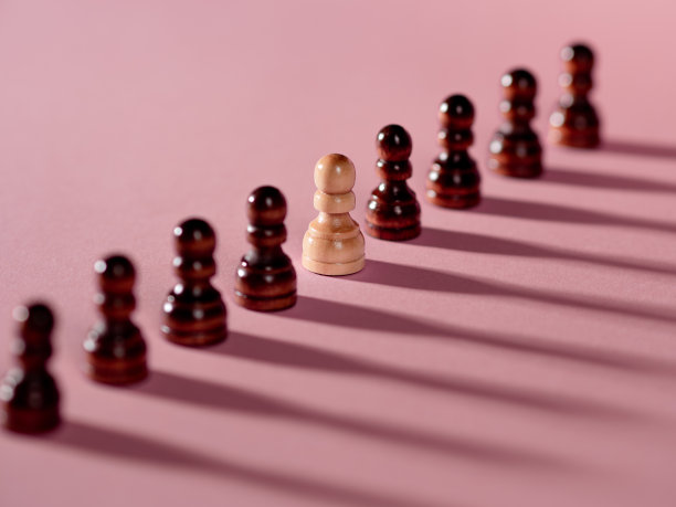 棋子排成一排，兵在粉红色的背景下，团队概念图片下载