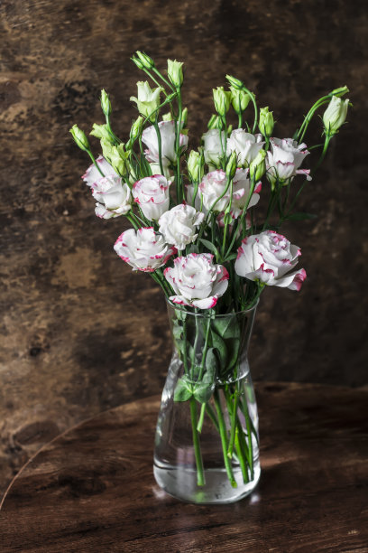 家居静物室内。在木制背景上的玻璃花瓶中的花束图片下载