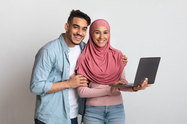手持笔记本电脑的快乐穆斯林夫妇肖像图片下载