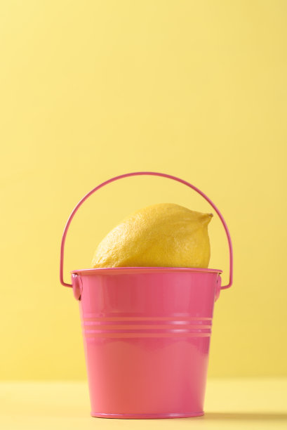 鲜柠檬，粉桶，黄色底色图片下载