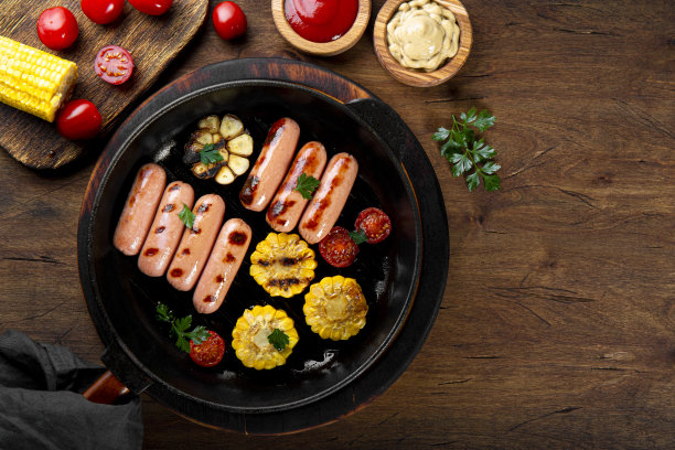 烤香肠配蔬菜和酱汁。夏日烧烤与香肠，玉米和西红柿在木制桌子上顶视图，照片与文本复制空间图片下载