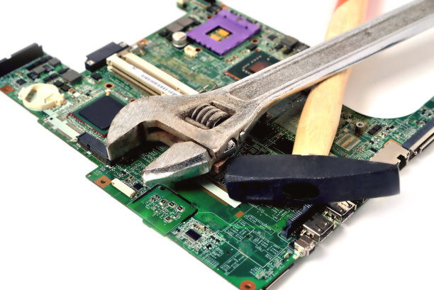 锤子和扳手在一个旧的微电路上的电脑在一个白色的背景，特写图片下载