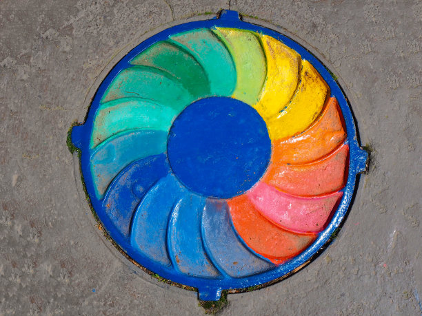 下水道舱口在灰色花岗岩表面上画上了整个彩虹图片下载