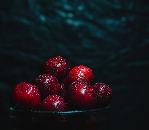 玻璃碗与红樱桃湿与水滴，在黑色背景，从上方照明，概念新鲜水果图片下载
