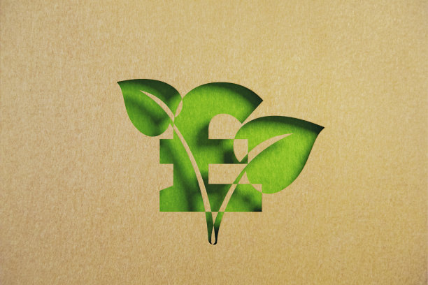 可持续发展的概念-剪出树叶形状的再生纸与英镑符号相交在绿色背景图片下载
