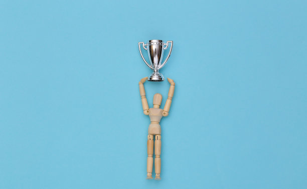 蓝色背景下，手持银杯的快乐木偶图片下载