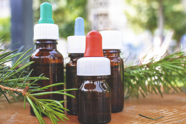 雪松和云杉精油在小玻璃瓶在木制背景。有选择性的重点图片下载