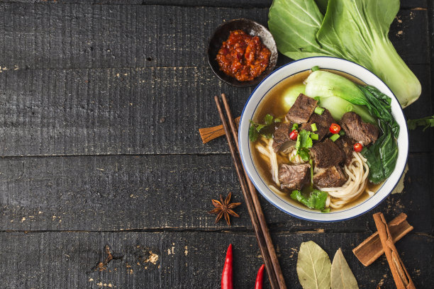 麻辣红汤牛肉面放在木桌上的碗里图片下载
