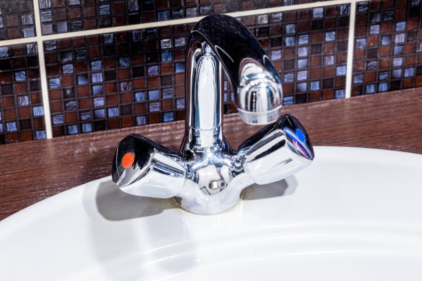 铬水龙头和白色陶瓷水槽关闭在家庭浴室。公寓浴室内部图片下载