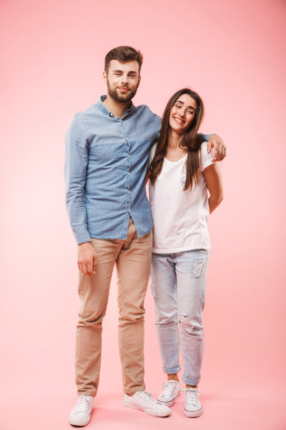 一个微笑的年轻夫妇拥抱的全长肖像图片下载