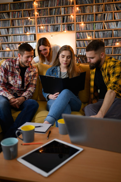 学生们在家里一起学习，一边使用笔记本电脑一边看书图片下载