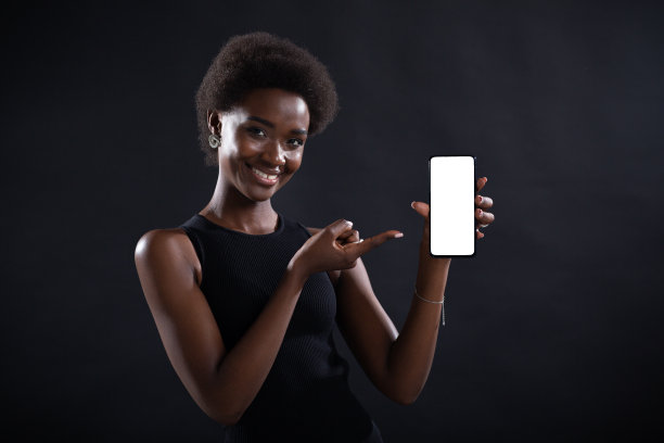 微笑的黑人妇女用手指指着空模板手机白屏幕图片下载