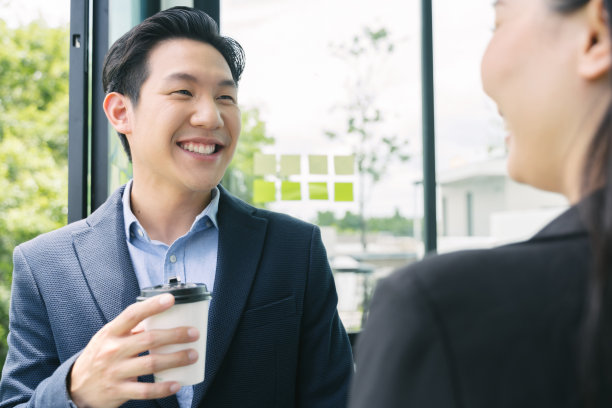 à¹快乐的亚洲商人同事们在办公室边喝咖啡边聊天图片下载