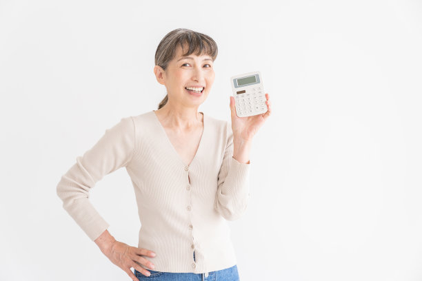 老年妇女有一个电子计算器，微笑图片下载