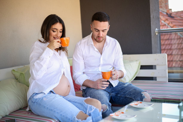 一名男子与孕妇聊天，因为她喝了一杯咖啡库存照片图片下载