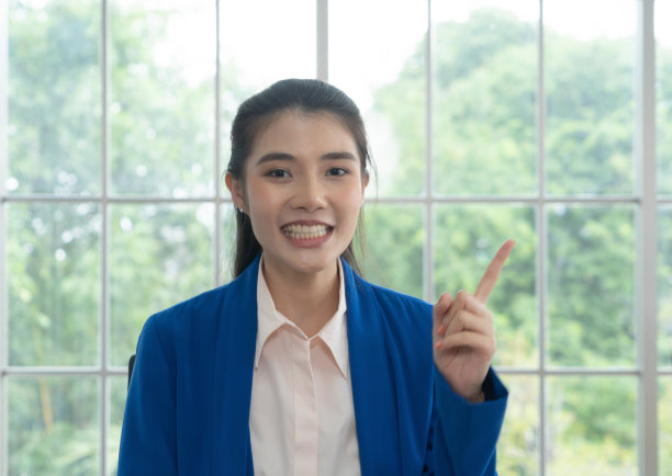 这是一幅微笑的亚洲商务女性的肖像，一个在家工作的泰国人，在冠状病毒大流行的检疫隔离中与她的同事在网络视频会议上交谈。图片下载