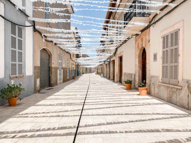 夏天镇上空荡荡的街道上挂着白色的纸，用于庆祝流行的节日图片下载