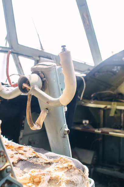 一架老式飞机驾驶舱的近距离特写。方向盘、仪表盘、座椅和爬升杆都可以看到。退役的飞机。所有的东西都时不时地破损。图片下载