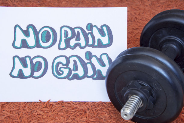 健身房的哑铃，贴着励志海报的壶铃/努力训练/在家积极锻炼。在家锻炼健康的生活方式图片下载