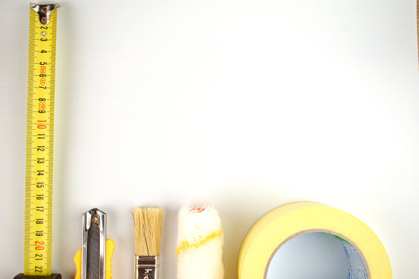 卷尺，油漆刷，施工刀，滚筒和黄色胶带。改造的概念。副本的空间。平的。图片下载