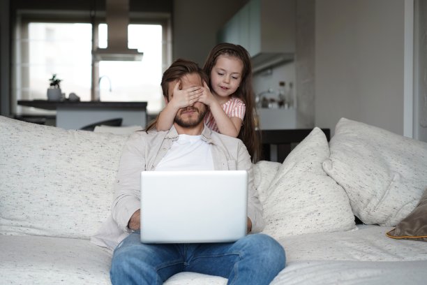 女儿在客厅打扰紧张的父亲。隔离期间在家工作图片下载