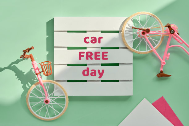 9月22日无车日。玩具模型城市自行车与薄荷绿色的背景阴影。平铺，俯视图，简约复古概念设计图片下载