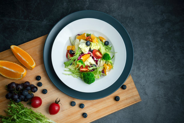 灰色的水泥地板上放着一盘美味健康的蔬菜沙拉。图片下载