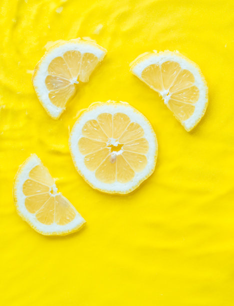 强烈的黄色柠檬柑橘片在水中波纹纹理夏季背景图片下载