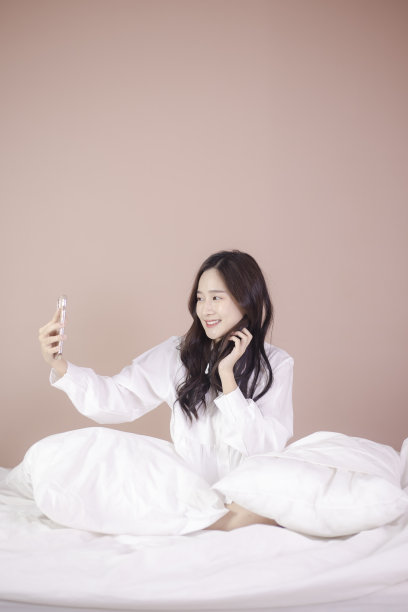 美丽的亚洲女人使用手机和互联网技术，使用在线聊天与她的朋友在家里图片下载
