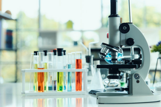 显微镜和试管用于化学实验室的科研桌上。图片下载