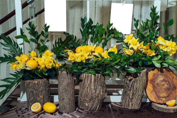 时尚的餐桌列表座位计划婚宴。餐桌婚礼客人名单上优雅的框板装饰黄色水仙花，柠檬和树桩与棕色布图片下载