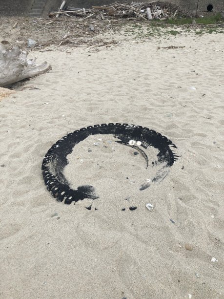 埋在沙滩上的一个轮胎。图片下载