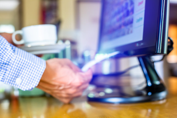 对收银员的选择性关注是在收银机打印收据，模糊端着咖啡杯为顾客服务图片下载
