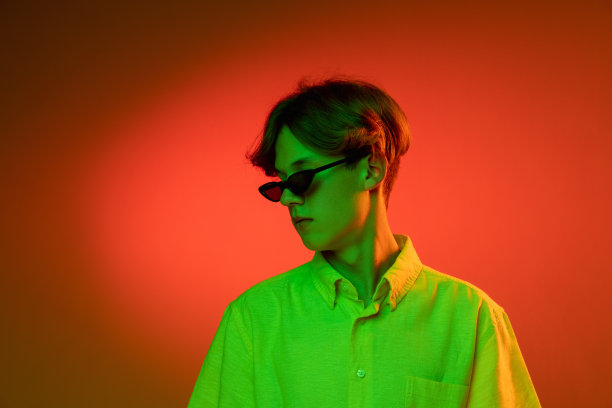 认真的。英俊的白人男子的肖像孤立在紫色的工作室背景霓虹灯，单色。美丽的男模。图片下载