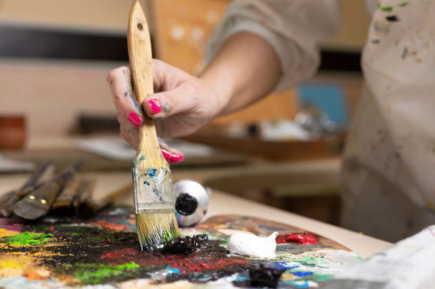 富有创意的女性画家在调色板中混合油画颜料。特写镜头。高质量的照片图片下载