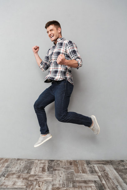 一个快乐的年轻人正在跳跃的全身像图片下载