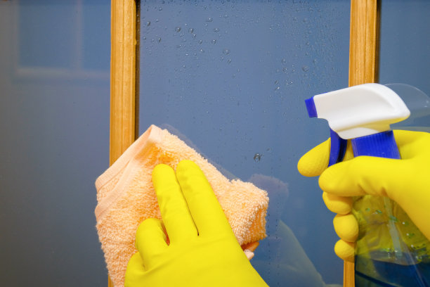 打扫房间时，用戴着手套的手擦拭门上的灰尘。清洁服务图片下载