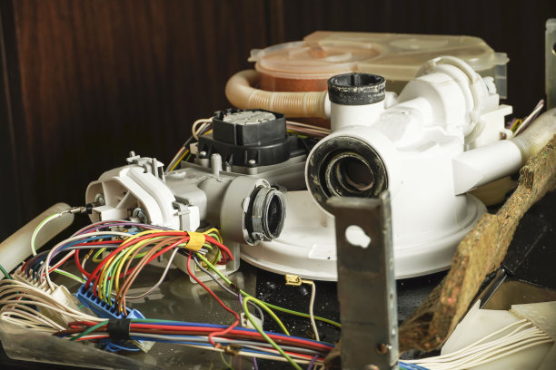 维修服务工作。成熟的修理工博主正在打开旧洗碗机。维修服务理念。洗碗机维修流程。金属零件上的鳞片。图片下载