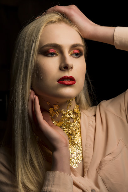 漂亮的年轻女子，浓妆艳抹，脖子上戴着金箔图片下载