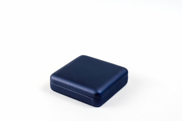 白色背景上的方形塑料小礼盒。封闭的蓝色盒子，戒指，耳环，袖扣和其他珠宝图片下载