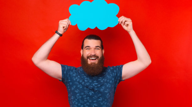 满脸胡子的兴高采烈的男人，在红色的背景上捧着空空的蓝色云彩图片下载