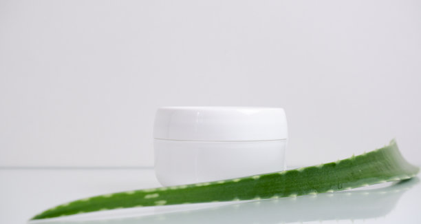 白色的化妆霜和芦荟叶在白色的背景。水疗中心的概念。图片下载