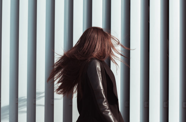 生活方式肖像的可爱的年轻模特的头发在风中飘扬，穿着时髦的服装图片下载