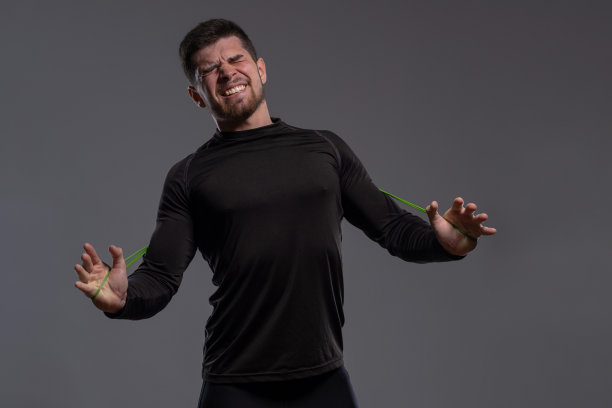 情绪激动的年轻运动员用手拉伸阻力带图片下载
