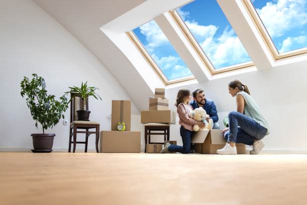 快乐的现代家庭搬到新房子，一起拆箱子。图片下载