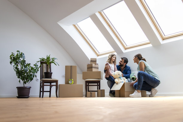 快乐的现代家庭搬到新房子，一起拆箱子。图片下载