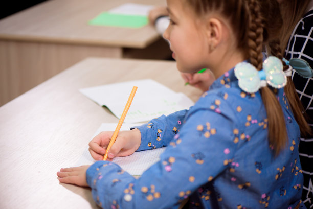 小学生坐在教室里听老师讲课。图片下载