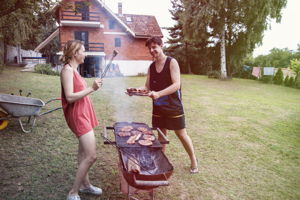 年轻幸福的夫妇在户外烧烤。图片下载