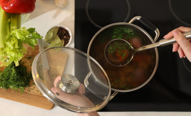 女人在炉子上煮肉汤，俯视图。自制的配方图片下载