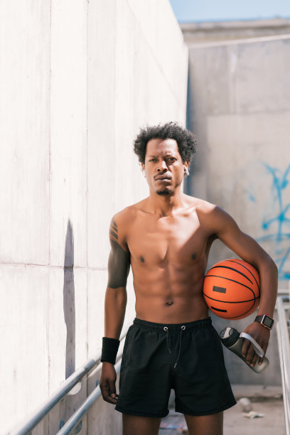黑人运动员在户外拿着篮球。图片下载